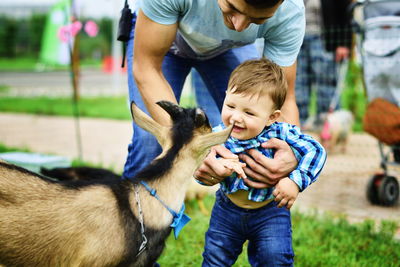 Boy smiling at goat