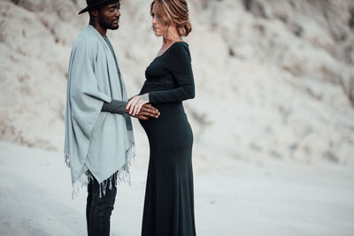 Side view of couple standing on beach