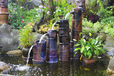 Potted plant by statue in garden