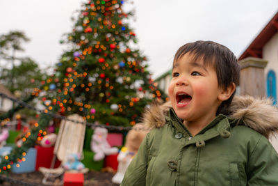 Boy behind the christmas tree