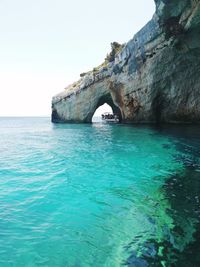 Scenic view of rock formation in sea against clear sky