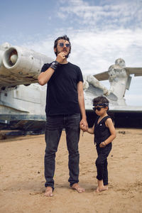 Family a boy and his father in rocker clothes stand  ekranoplan plane by the sea in dagestan