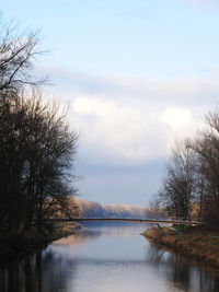 Scenic view of river against cloudy sky