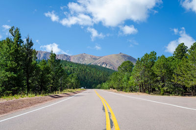 Road amidst trees against sky