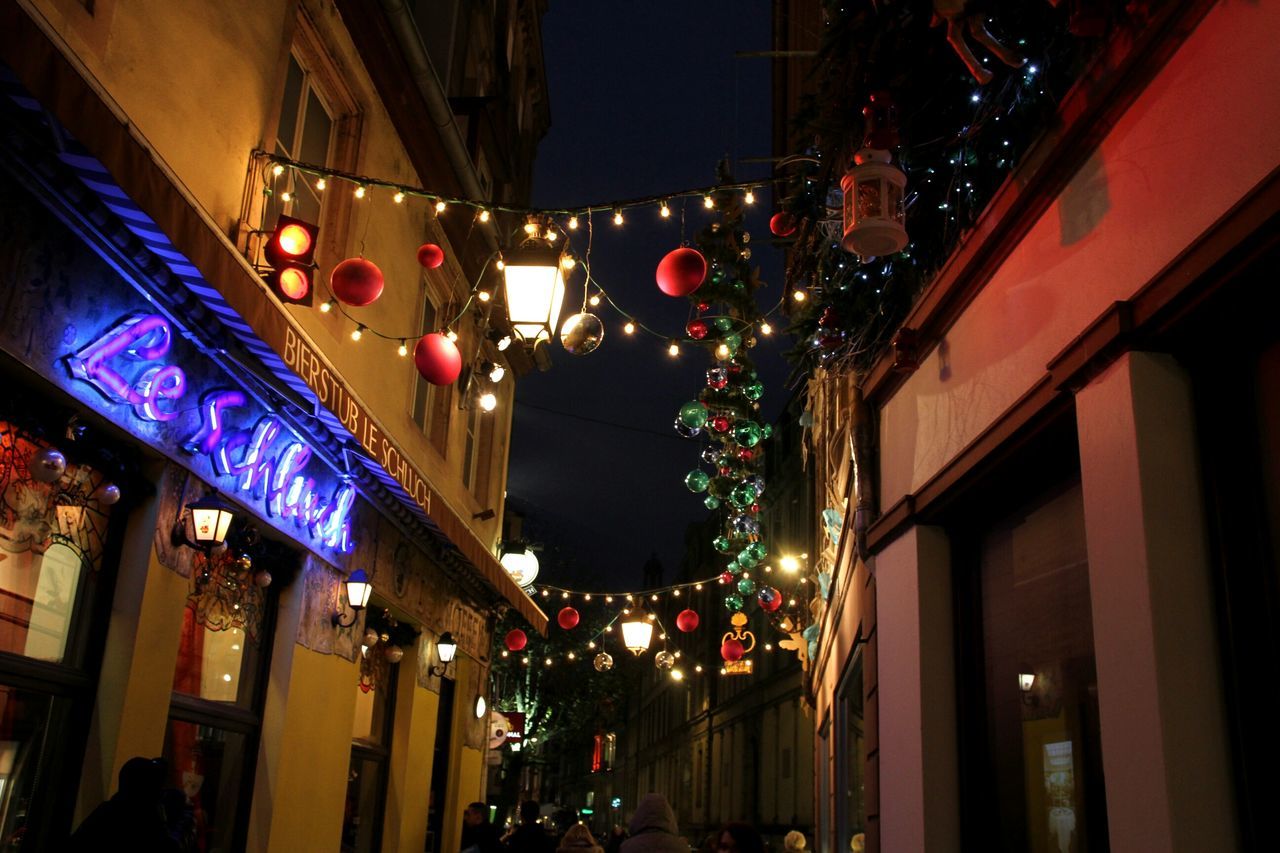 illuminated, night, architecture, built structure, lighting equipment, building exterior, celebration, decoration, city, low angle view, light - natural phenomenon, street light, multi colored, christmas, christmas lights, christmas decoration, street, hanging, building, city life