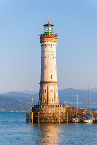 Lighthouse by sea against sky