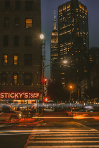 Illuminated city street and buildings at night