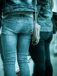 Midsection of female friends wearing jeans