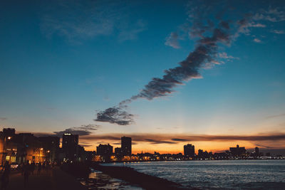 Silhouette buildings against sky at sunset