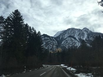 Road amidst snowcapped mountains against sky