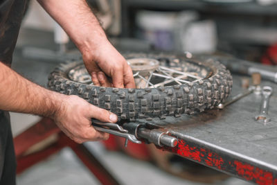 Midsection of man repairing wheel