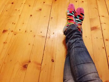 Low section of woman standing on wooden floor