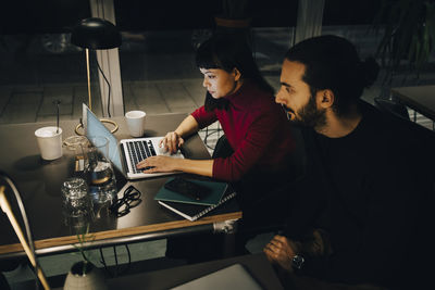 Multi-ethnic colleagues planning strategy while working late at coworking space