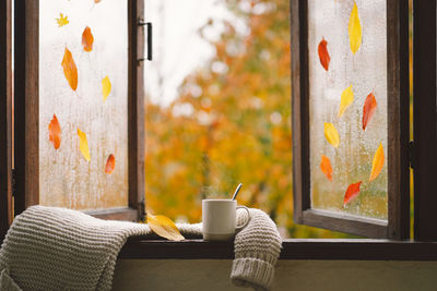 Still life details in home on a wooden window. sweater, hot tea and autumn decor