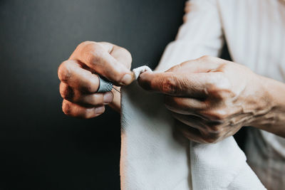 Midsection of man holding cigarette