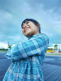 Portrait of smiling girl against sky