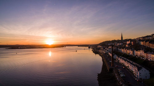 View of city at waterfront during sunset