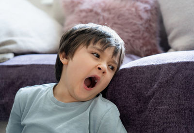 Portrait of boy lying on sofa at home