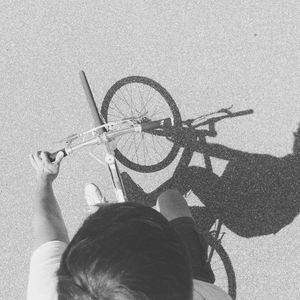 Portrait of woman with bicycle in shadow