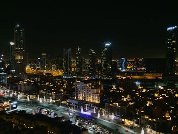 Illuminated cityscape against sky at night