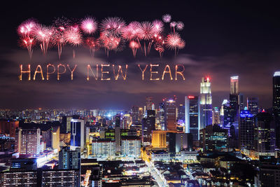 Firework display over illuminated buildings in city at night