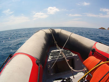 Close-up of boat sailing on sea against sky