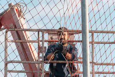 Low angle view of young man standing against sky