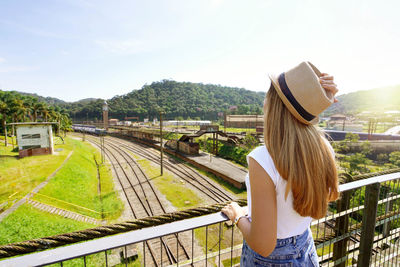 Traveler girl looking the old train station with clock tower of paranapiacaba, sao paulo, brazil