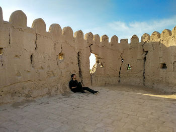 Man sitting on stone wall