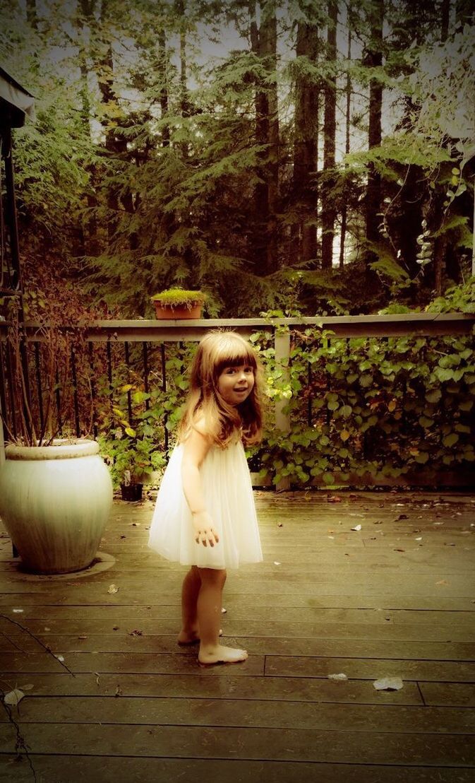 GIRL SMILING WOMAN AGAINST PLANTS