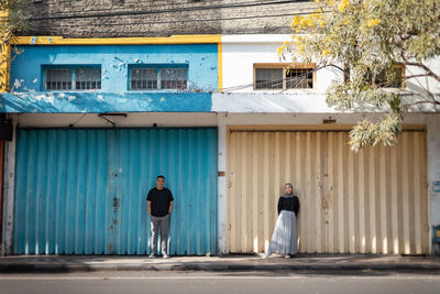 Rear view of man standing in front of house