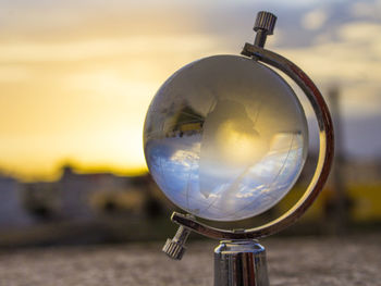 Close-up of crystal ball against sky