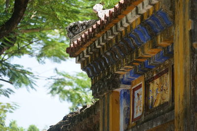 Low angle view of old building by trees