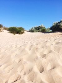 Scenic view of desert against clear blue sky