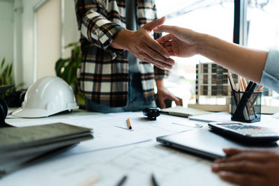 Midsection of business colleagues working on table