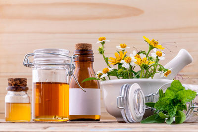 Various cooking oils in bottles by plants on table