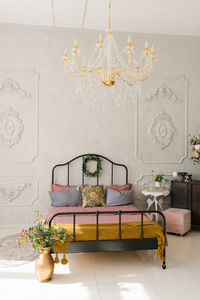 Neoclassical bedroom interior. a bed with a pink bedspread and gray pillows. flowers in a vase