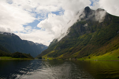 Scenic view of lake by mountains against sky