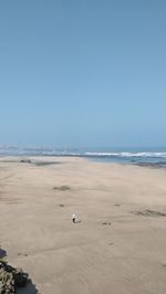 Scenic view of beach against clear blue sky