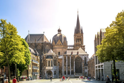 People by cathedral against clear sky