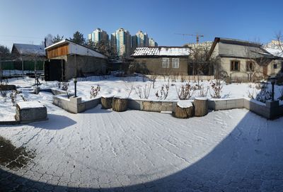 Snow covered built structures against clear sky