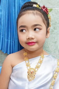 Close-up of cute girl wearing jewelry at home