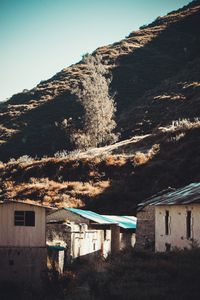 Scenic view of old building by mountains against clear sky