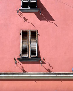 Low angle view of pink building and window