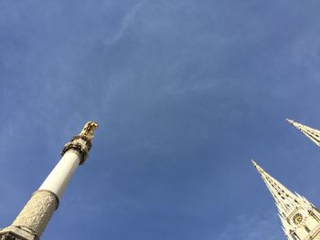 Low angle view of smoke stacks against blue sky