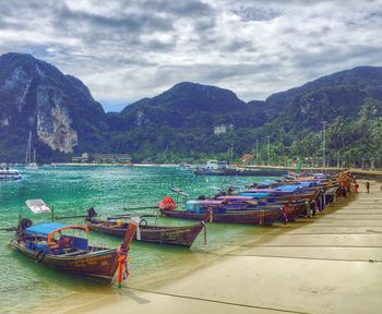 View of boats in sea against cloudy sky