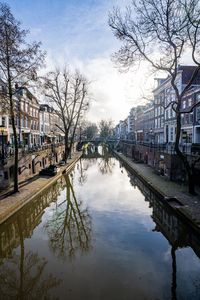 Canal amidst buildings in city against sky