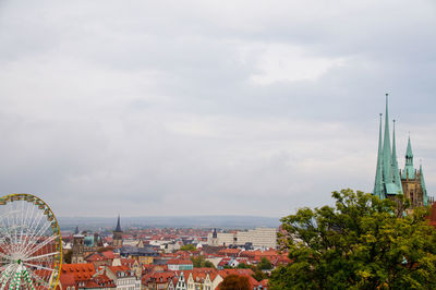 Cityscape by sea against sky