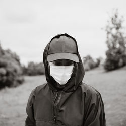 Portrait of a young woman in black hoodie and medical mask. mood 