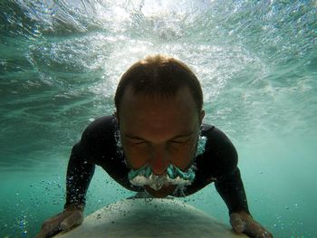 Close-up of young woman swimming in sea